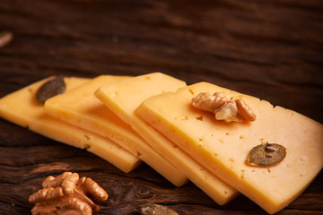 Traditional Dutch semi hard cheese served close up on rural table with sacking. Selective focus