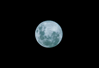 Naklejka na ściany i meble Blue Moon isolated on a dark black sky