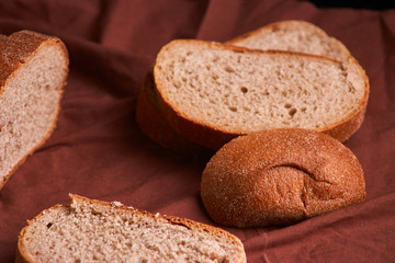 Bakery - gold rustic crusty loaves of bread and buns on black chalkboard background. Still life captured from above