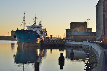 Fototapeta premium Fishing port with river and ship in spring sunny evening