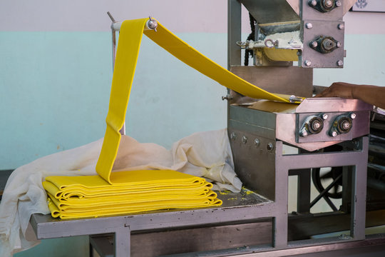 noodle making machine in process of transforming yellow rice flour into noodle