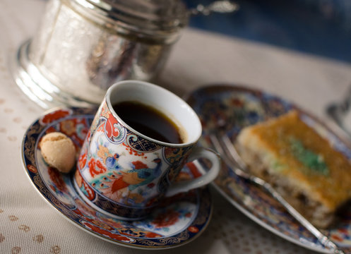 Vintage set of beautiful painted cup of coffee, honey cake Baklava and sugar bowl. Selective focus.