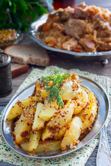 Sliced roasted mustard potatoes with grains, selective focus