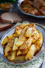 Sliced roasted mustard potatoes with grains, selective focus
