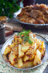 Sliced roasted mustard potatoes with grains, selective focus