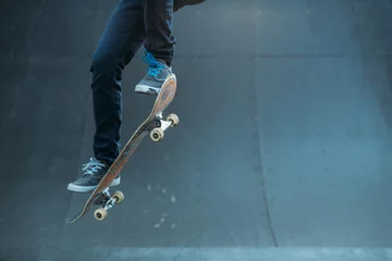 Afwasbaar fotobehang Skateboarding hobby. Man active life. Guy on skateboard performing ollie trick on ramp. Copy space. © golubovy
