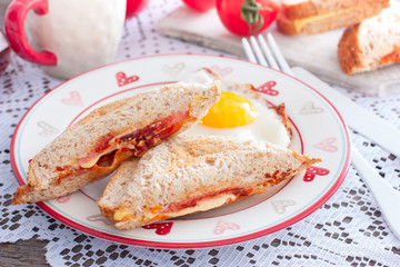 Breakfast with scrambled eggs and closed hot sandwich with cheese, tomatoes and sausage, horizontal