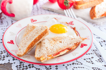 Breakfast with scrambled eggs and closed hot sandwich with cheese, tomatoes and sausage, horizontal