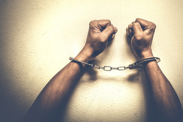Hands on white cement surface with handcuff