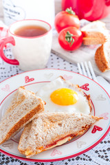 Breakfast with scrambled eggs and an open sandwich with cheese and sausage, selective focus
