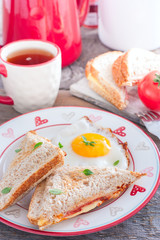 Breakfast with scrambled eggs and an open sandwich with cheese and sausage, selective focus