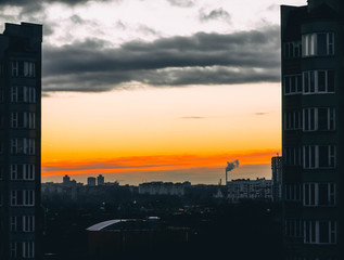 Naklejka premium dawn sunset in a European city, the rays of the sun among the houses.