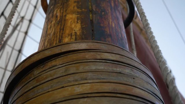 The stacking of gaff rings on the mast as the sail is lowered