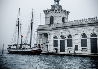 Fototapeta na wymiar Venice / Italy 19 february 2019 :historic building and a big Sailing boat at venice docks photo taken from 