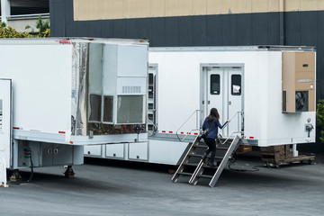 Woman walking up a stair into her trailer in media studio area