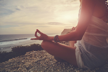 Young woman practicing yoga - meditation on the beach.
