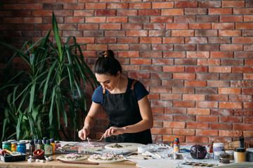Ceramic craft artwork in process. Incense fragrance inspiration. Young woman with modeling tools. Copy space.