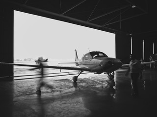 Private luxurious small aircraft entering hangar - obrazy, fototapety, plakaty