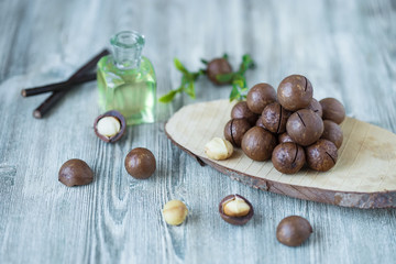 Macadam nuts, walnut oil, on wooden background. Relax, health care, body care