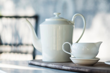 White tea pot and cup set on granite table