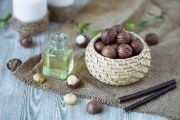Fototapeta na wymiar macadamia kernels, walnut oil, on wooden background. Relax, health care, body care
