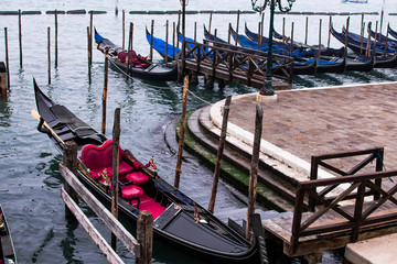 Fototapeta na wymiar Venice / Italy 19 february 2019 :Gondols ,the symbol of venice , parked in the canal