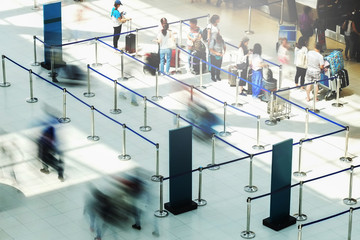 Abstract motion blurred image of people at the airport walking in line to their check in or...