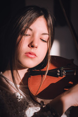 Ragazza mentre suona il violino in casa