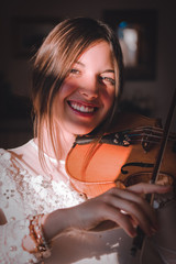 Ragazza mentre suona il violino in casa