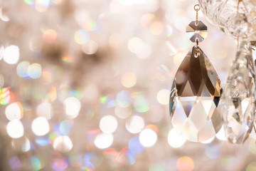 Close up image of crystal on chandelier with bokeh background