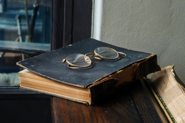 Vintage glass on old worn out leather cover book