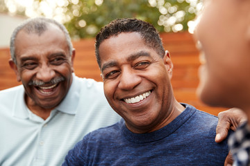 Three generations of family men laughing together, close up - Powered by Adobe