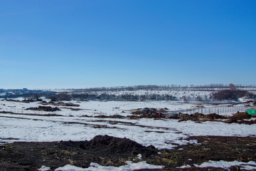 the beginning of spring snow melting in the fields under the spring sun