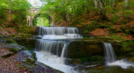 Fototapeta premium Waterfall under stone bridge in Rhodope mountain near Sitovo village, Bulgaria, Europe, spring photography