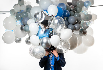 Handsome happy man with big bunch of balloons. Bearded man with balloons at birthday party. Stylish birthday guy holds air balloons. Happy businessman with helium balloons. Happy birthday concept.
