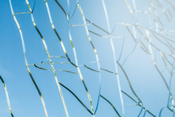 Cracked transparent window glass with blue sky background