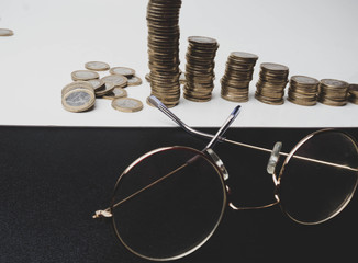 Row of coins,glasses on table, finance and banking concept, matte