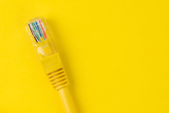 Yellow LAN, Local Area Network Cable With Colorful Wire In Connector On Solid Yellow Background With Copy Space, Internet Connection Or Networking Concept