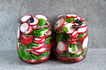 Fototapeta na wymiar Radish salad with spinach in a jar. Fitness salad in the jar. Fresh radishes and fresh chopped spinach leaves. Vegetable salad in a jar to go.