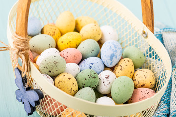 Metal basket with colourful Easter quail eggs. Spring holidays concept