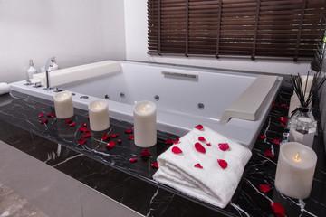 Candle decoration be the bath tub with some roses petal