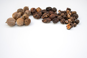 triphala ayurvedic medicinal plant comprise of  organic chebulic myrobalan fruit, organic amla fruit, and organic belleric myrobalan fruit on white background with copy space