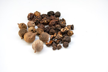 triphala ayurvedic medicinal plant comprise of  organic chebulic myrobalan fruit, organic amla fruit, and organic belleric myrobalan fruit on white background with copy space