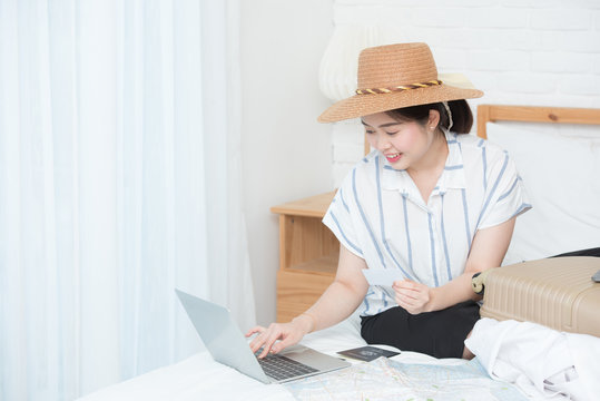 Young Asian Girl Preparing For Travel Vacation By Use Laptop And Tablet And Paid By Credit Card For Booking Tour.online Booking Or Online Commercial Concept.