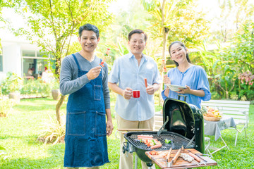 Obraz premium Group of people picnic party in home garden with bbq food