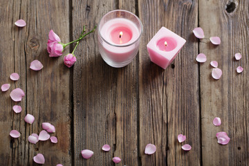 candles and roses on wooden background