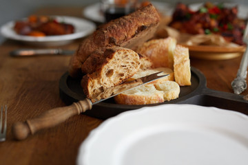Closeup view of a plate of fresh bread served on dinner table on domestic kitchen