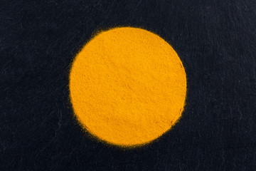 Curcuma turmeric spice powder on black slate background