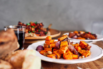 Low angle view of table served with traditional British Sunday roast dinner, featuring roasted chicken, squash and sweet potatoes