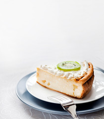 Homemade cottage cheese cake with kiwi fruit and cream on a plate